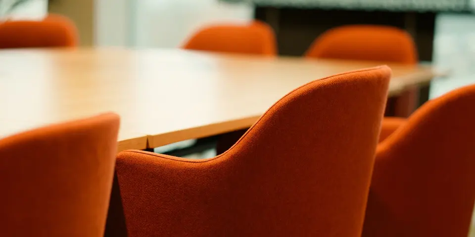 A quiet meeting room with an empty table and chairs